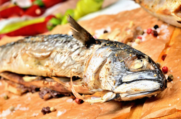 istock Smoked mackerel with garlic, pepper and coarse salt on baking paper. 1258044209