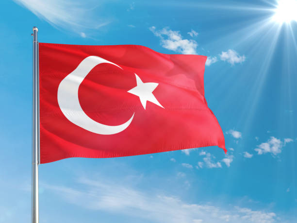 istock Turkey national flag waving in the wind against deep blue sky. High quality fabric. International relations concept. 1258044421