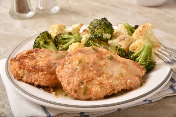 istock Breaded chicken breasts baked in lemon, caper and white wine sauce served 1258050443