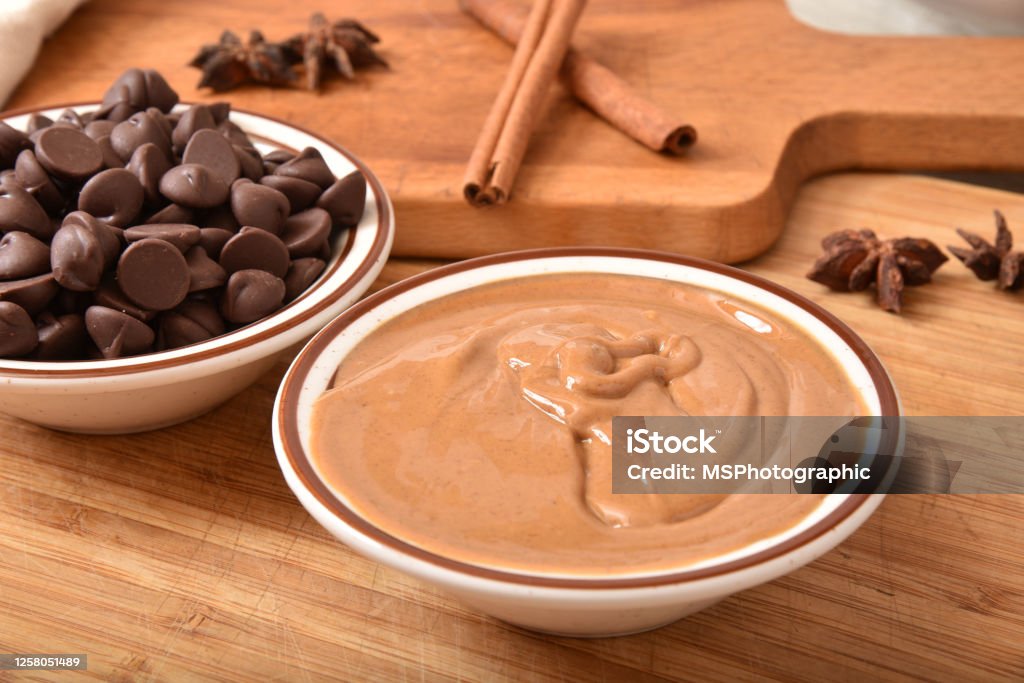 Bowls of creamy peanut butter with dark chocolate chips Bowls of creamy peanut butter with dark chocolate chips, cinnamon and star anise for holiday baking Peanut Butter Stock Photo