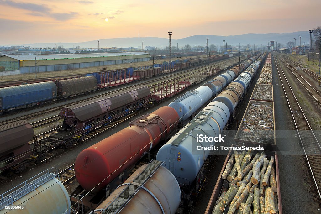 Trenes y del transporte de mercancías ferroviario en la puesta de sol - Foto de stock de Tren de carga libre de derechos