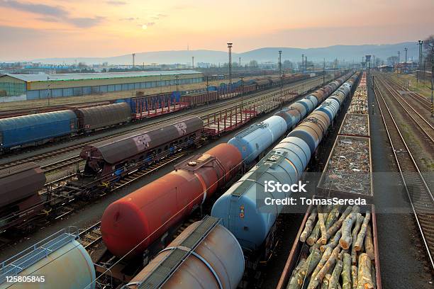 Trenes Y Del Transporte De Mercancías Ferroviario En La Puesta De Sol Foto de stock y más banco de imágenes de Tren de carga