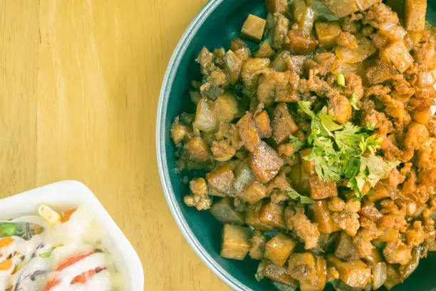 Stir Fried Pork with Onion and Garlic and Black Soy Sauce and Coriander Topping and Tofu and Vegan Salad on Right Frame and Flaylay View in Vintage Tone