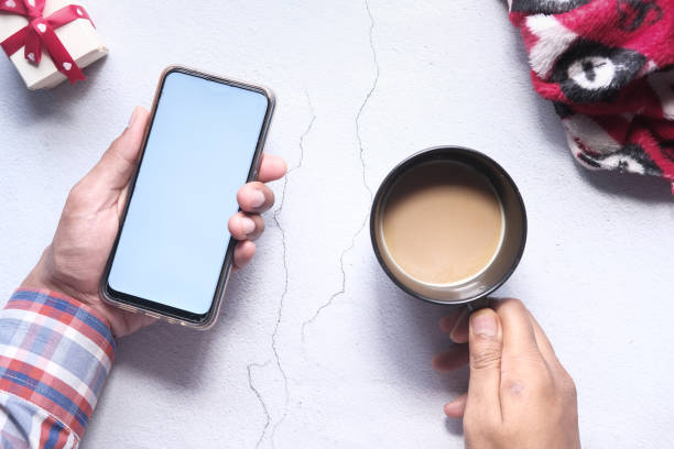 istock flat composition of hand holding smart phone and coffee on table 1258064919