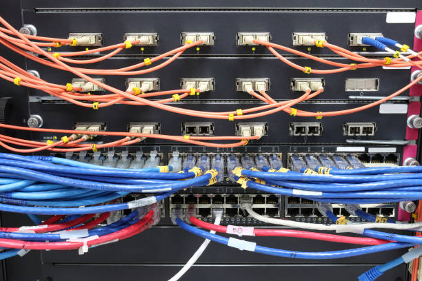 istock cable network, fiber optic cable connect to switch port in server room ,Concept network management 1258066709