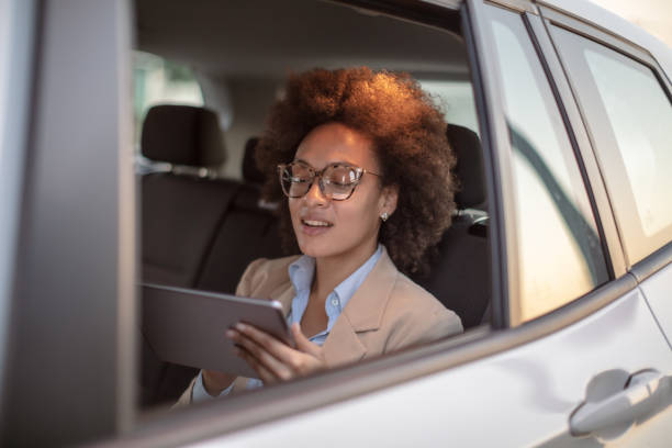 istock Business woman using digital tablet in a car 1258073084