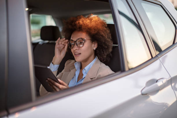 istock Business woman using digital tablet in a car 1258073715