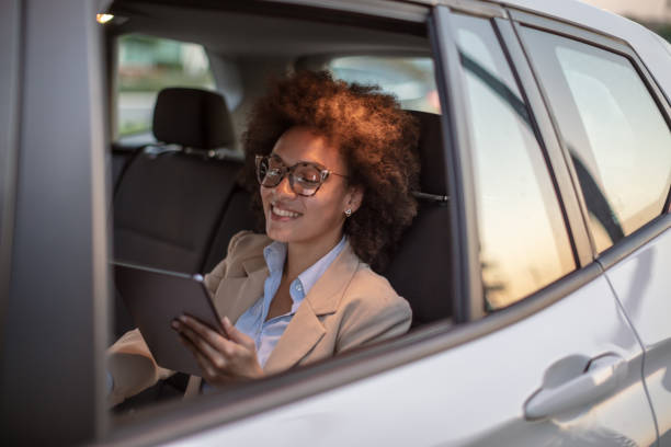 istock Business woman using digital tablet in a car 1258073850