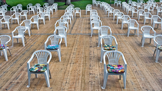 Augsburg, Germany - July 18, 2020: Chairs in the finishing stages of being arranged according to the Covid-19 regulaions for an outdoor concert in a public park.