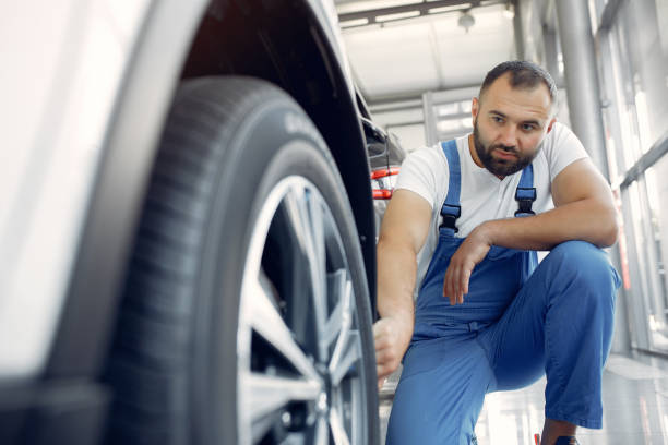 istock Handsome man in a blue uniform checks the car 1258075524