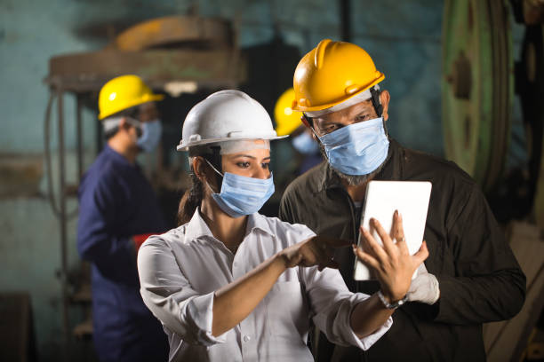 geschäftskollegen mit digitalem tablet im werk - industriearbeiter stock-fotos und bilder