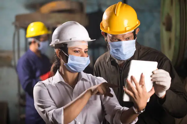 Photo of Business colleagues using digital tablet at factory