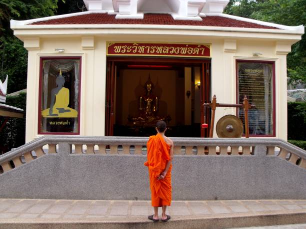 el monje budista observa una imagen de buda en un templo de bangkok, tailandia. - monk meditating thailand bangkok fotografías e imágenes de stock