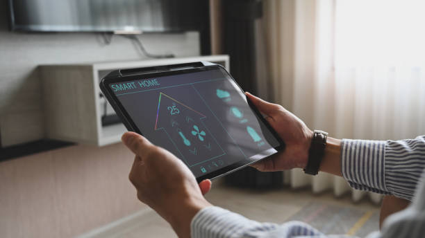 istock Cropped image hands are using a tablet with home devices controlled applications on the screen. 1258086136