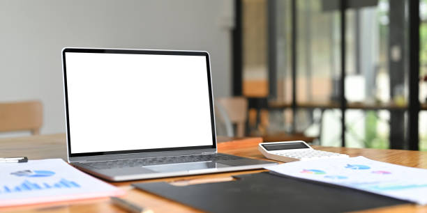 istock A wooden working desk is surrounding by a white screen computer laptop, paperwork, and office equipment. 1258086210