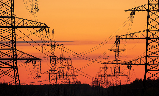 industrial landscape. Electric furnace lines with towers on a sunset background