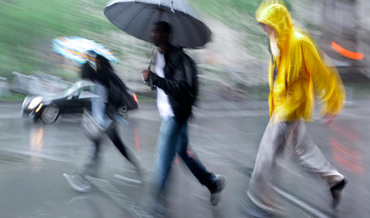 people walking in the street on a rainy day motion blurred