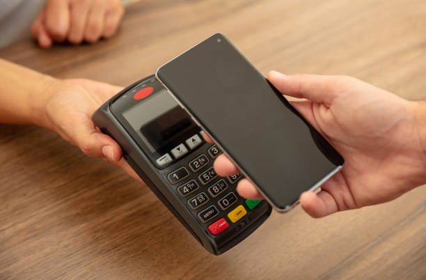 istock POS terminal for payment with smartphone, nfc technology. Cashier and customer hands 1258092770
