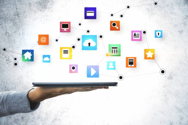 istock Hand holding tablet computer with glowing online networking cloud icons 1258092846