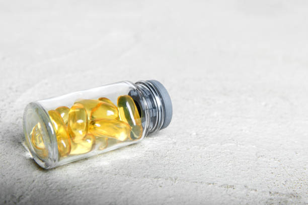 istock Omega-3 (fish oil capsules) in a glass bottle on a gray concrete background. 1258094936