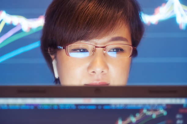 istock Woman looking stock market Data on computer 1258095435