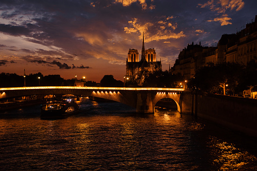 View of the embankment of the Seine River and Notre Dame de Paris at sunset. Paris,France