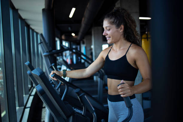 istock Sportswoman or athlete smiling on training while running on treadmill machine in the gym. Happy and positive people workout. 1258100584