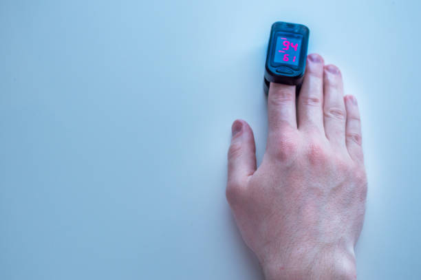 pulse oximeter is placed on the index finger of a man’s hand to measure saturation. Close-up. pulse oximeter is placed on the index finger of a man’s hand to measure saturation. Close-up. oxygen monitor stock pictures, royalty-free photos & images