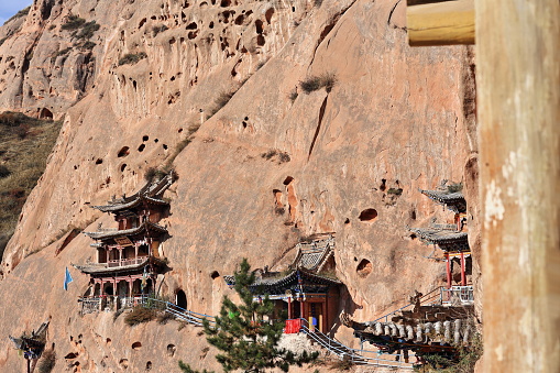 Wooden pavilions clinging to the red sandstone cliff. Qianfo-Thousand Bhudda Buddhist grottoes section in the Mati Si-Horse Hoof Temple. Sunan Yugur Autonomous county-Zhangye-Gansu province-China.