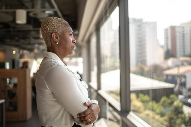 istock Serious businesswoman looking through the window 1258107707