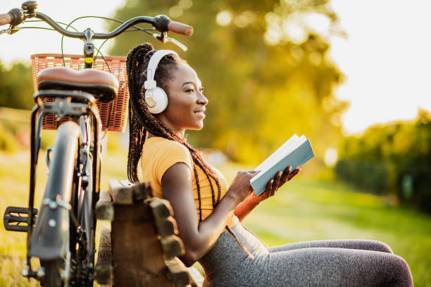 istock Young woman is reading a book in nature 1258107853