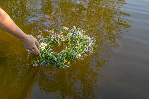 A wreath of wildflowers in the river. Tradition, a girl weaves a wreath of flowers and sends a wreath along the river.