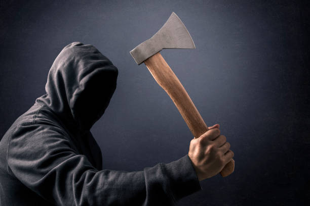 Hooded man with an axe in the dark
