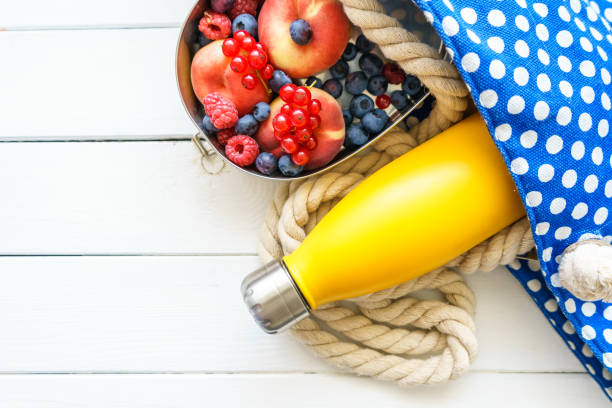 strandtasche mit wasserflasche und frischem obst in einer dose - can fruit peaches healthy eating stock-fotos und bilder