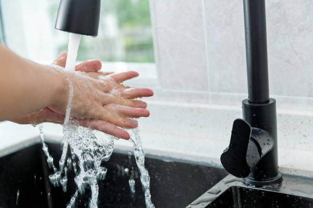 istock Woman washing hands under running water 1258115909