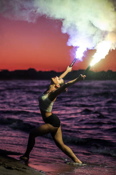 istock Free Woman Meditating With Lighted Torch On The Beach 1258117189