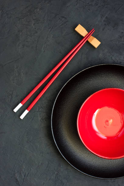 istock Two chopsticks next to  black and red bowl. Asian style 1258118206