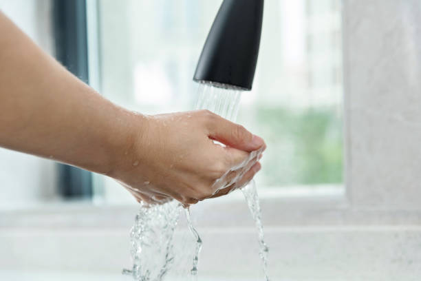 istock Woman washing hands under running water 1258119272