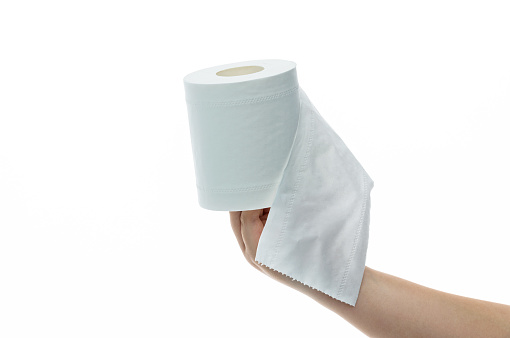 Hand holding a roll of toilet paper on white background.