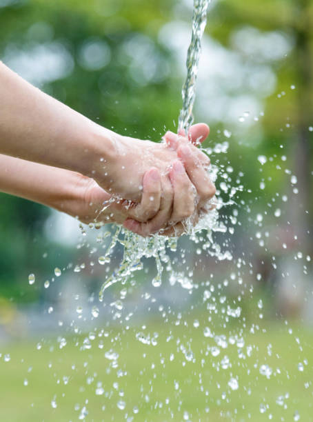 istock Woman washing hands under flowing water 1258124263