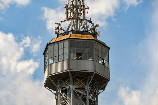 Prague, Czech Republic - August 2018:  Close up of the observation deck and mast on the Petrin Tower which is located on Petrin Hill above the city of Prague. People are looking out from open windows of the observation deck.