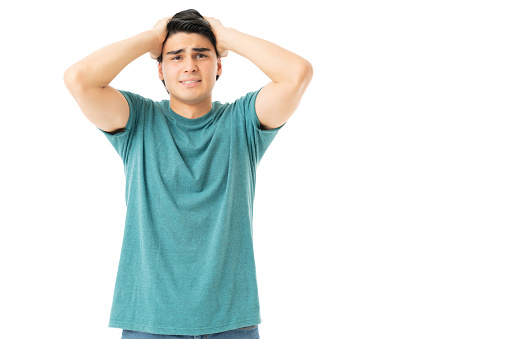 Hispanic young man with frustrated expression isolated on white background