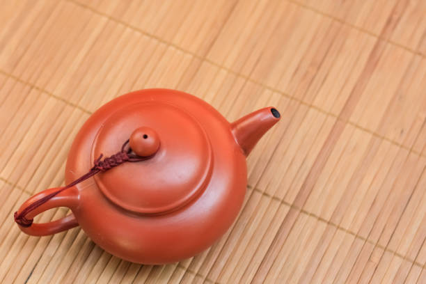 istock old brown ceramic teapot on bamboo Mat. 1258126633