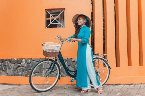 Young woman in vietnamese dress with bicycle