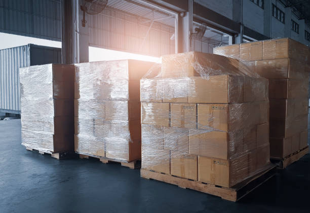 istock Stacked of shipment boxes on pallets waiting for load into container truck. Cargo freight export and import. 1258133243