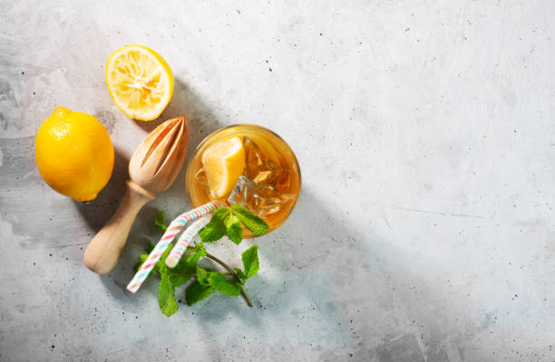 istock Lemon ice tea on concrete gray background with mint and ice, flat lay 1258134358