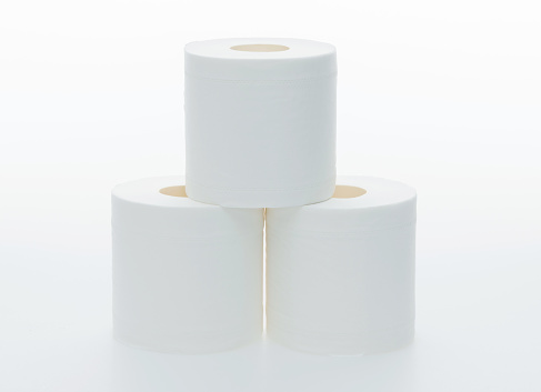 Three rolls of white toilet paper on white background.