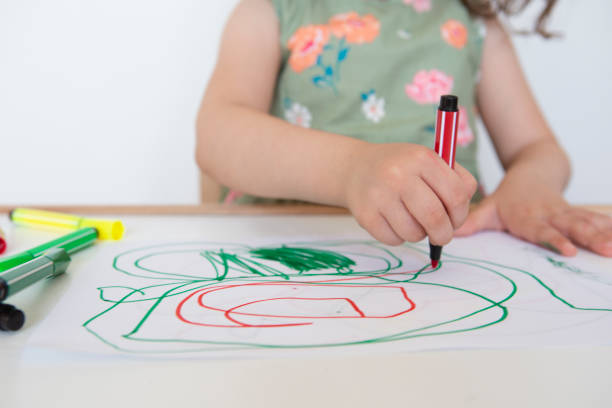 Little girl drawing on white paper