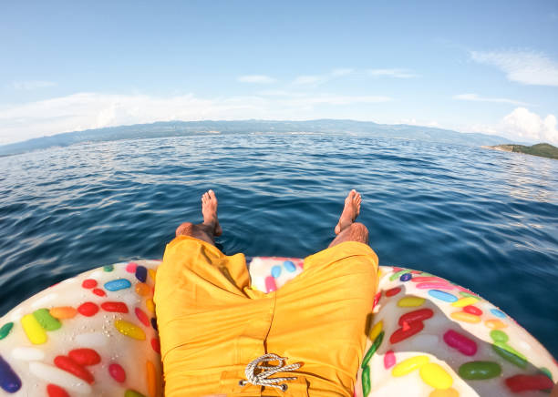 istock Man on floating doughnut in the sea 1258138472