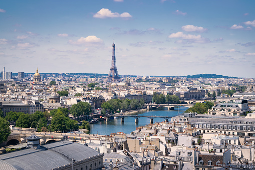 High angle view of central Paris with historic buildings, and the River Seine. Invalides and the Eiffel Tower in the background.